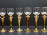 six verres à vin sont alignés sur une table