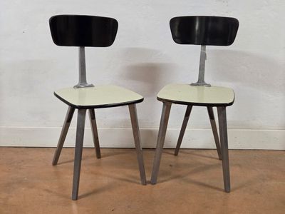 two black and white chairs sitting next to each other on a hard wood floor