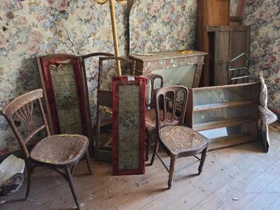 plusieurs chaises et une table dans une pièce dont l'un des murs est tapissé