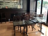 tables and chairs in a restaurant with a large mirror on the wall