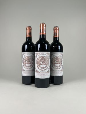 trois bouteilles de vin rouge posées sur une table