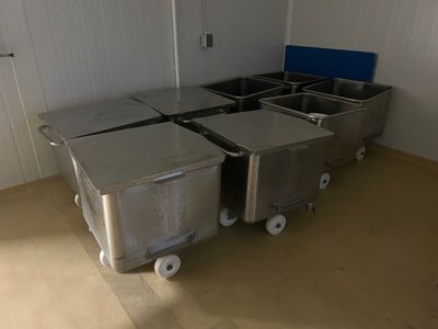 four bins on wheels in a room with white walls