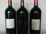 three bottles of red wine are lined up on a table
