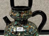 un vase muni d'une anse, posé sur une table