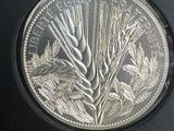une image représentant une pièce d'argent sur laquelle figure du blé