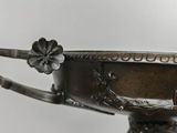 an antique silver plate on a stand with a flower decoration