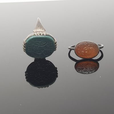 two rings with a coin and a ring with a face on them