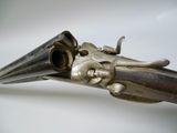 a close up of a gun on a table with a white background