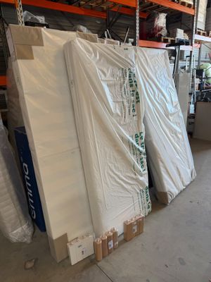 many mattresses stacked up in a warehouse with pallets