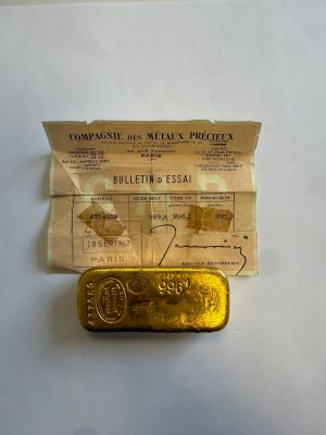 un vieux lingot d'or posé sur une feuille de papier