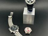 two watches and a watch stand on a black surface