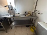 une cuisine avec une table en inox et un seau jaune posé par terre