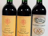 trois bouteilles de vin sont alignées sur une surface blanche