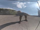 a reflection of a skateboarder on the side of a car