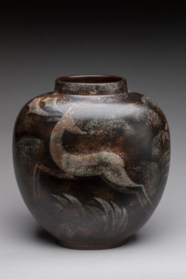 l'image d'un vase orné d'un oiseau, posé sur une surface grise