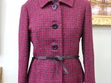 the jacket is pink and black with a black belt on a mannequin