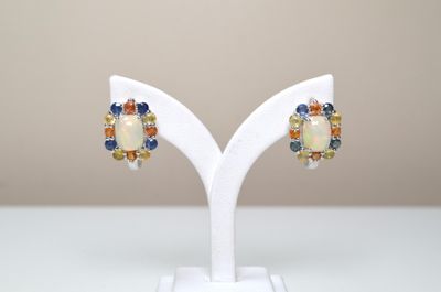 un gros plan sur une paire de boucles d'oreilles posées sur un présentoir blanc