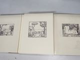 three books with drawings on them sitting on a table