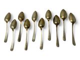six spoons are lined up in a row on a white surface