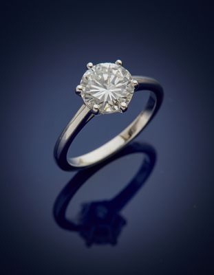 a single stone diamond ring on a blue background