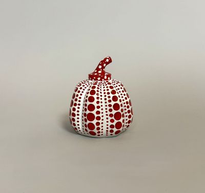 a white and red dotted pumpkin sitting on top of a table