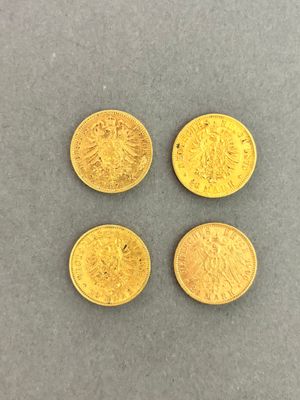 four gold coins, one of which is a sovereign and one of which is a sovereign