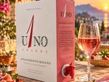 une boîte d'Uno Grande à côté d'un verre de vin
