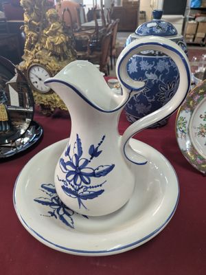 a blue and white pitcher and plate on a red table cloth