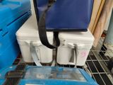 a blue cooler and a white cooler on a shelf