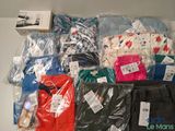 de nombreux t-shirts et pantalons de différentes couleurs sur une étagère