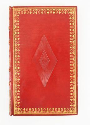 un vieux livre rouge aux bords dorés sur fond blanc