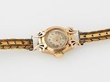 une image représentant une montre-bracelet en or ornée d'un diamant au centre