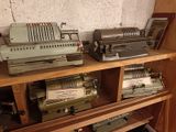 several old typewriters are sitting on a shelf in a room