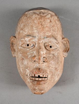 a clay mask of a man ' s face on a gray background