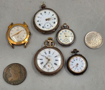 many different types of pocket watches on the table