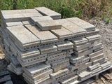 a pile of bricks sitting on a pallet in the dirt