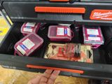 someone is holding a tool box full of money and other items