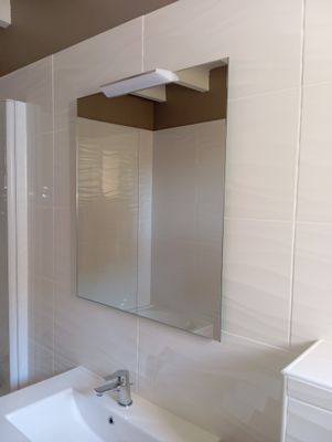 a bathroom with a sink, mirror, and shower in it