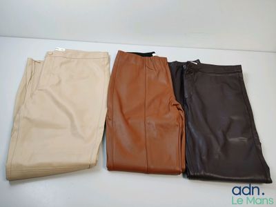 three pairs of leather pants sitting on top of a white table