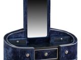a blue velvet dressing table with a mirror and drawers