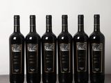 six bouteilles de vin sont alignées sur une table en bois