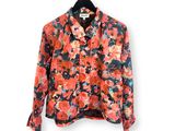 une chemise à motifs floraux orange et noire suspendue à un cintre