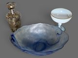 un bol bleu et un vase argenté posés sur une table
