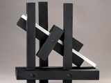 black and white sculpture of blocks on a stand against a gray background