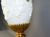 un vase blanc orné d'un motif doré sur le dessus