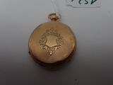 a gold pocket watch with a chain on a white surface