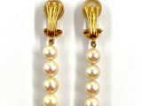 deux paires de boucles d'oreilles en perles et en or posées sur un fond blanc