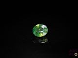 a close up of a green and white diamond on a black surface