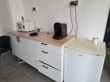 a small kitchen with a refrigerator and a microwave on the counter