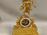 une horloge en or surmontée d'une statue